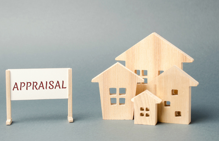 Wooden house models and an "APPRAISAL" sign, representing the valuation process in real estate.